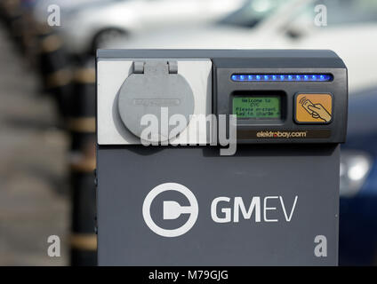 Punto di ricarica per veicoli elettrici Gmov, punto di ricarica per auto elettriche di fronte alle auto sfocate con messa a fuoco morbida nel parcheggio Bury council nel lancashire uk Foto Stock