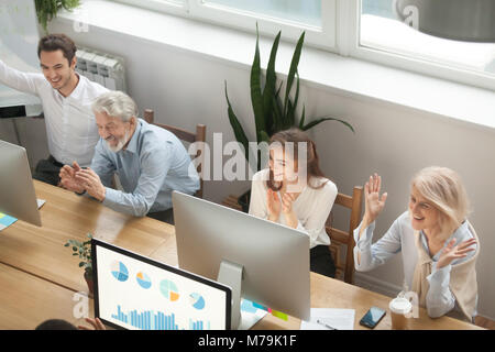 Emozionato motivati giovani e vecchi colleghi applaudire celebratin Foto Stock