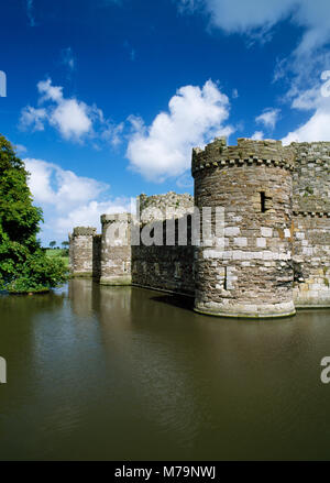 Guardando verso nord attraverso il fossato a sud-ovest la torre e la cortina esterna parete di Edward ho il castello. Beaumaris, Anglesey, Galles del Nord. Foto Stock