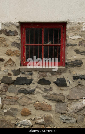 Quadrato Rosso nella finestra di legno in una pietra dipinta di bianco e di parete di un garage o casa Foto Stock