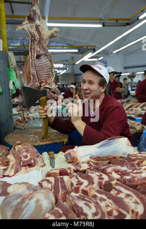 Un macellaio è commercializzata nella gamma di carne del mercato Dorogomilovskiy nel centro di Mosca, Russia Foto Stock