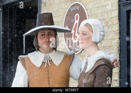 Le figure di un uomo e di una donna al di fuori di Oliver Cromwell house di caduta di neve, Ely, Cambridgeshire, Inghilterra Foto Stock