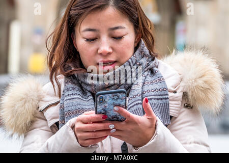 Monaco di Baviera / Germania - 15 febbraio 2018: Asian Lady usando il suo smartphone Foto Stock