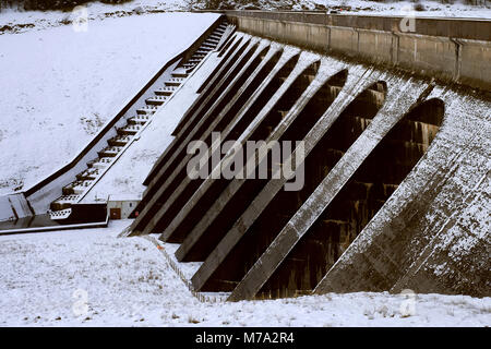 Nant y Moch diga del serbatoio contrafforti e overflow nella neve Foto Stock