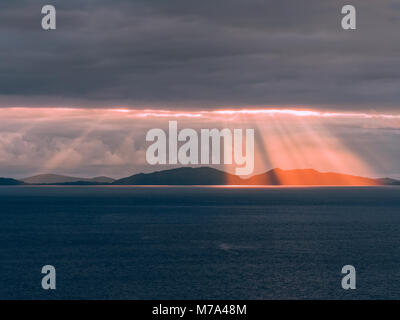 Tramonto sul Ebridi Esterne, come si vede dal punto Neist scogliera sull'Isola di Skye. Drammatica raggi di luce raggiante attraverso le nuvole scure. Foto Stock