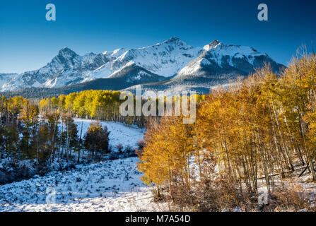 Il polo nord di picco e Hayden picco nella gamma Sneffels, sotto la neve, Aspen Grove in caduta delle foglie, vista al sunrise da ultimo dollaro Road, San Juan Mountains, Foto Stock