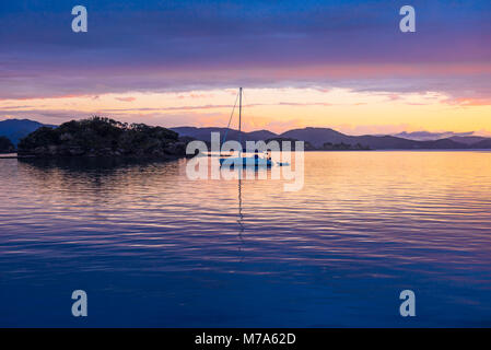 Tramonto con yacht ancorati off Urupukapuka Island nella Baia delle Isole, Isola del nord, Nuova Zelanda Foto Stock