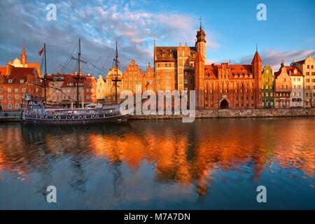 Caravel ormeggiati da un lungo argine sul fiume Motlawa nella Città Vecchia di Danzica, Polonia a sunrise. Mariacka cancello sulla destra Foto Stock