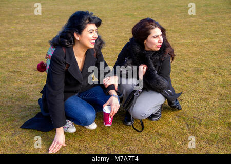 Due studenti di sesso femminile, Parisian-Algerian Faiza Faa (sinistra) e il suo amico Samar Munaf dall'Iraq (a destra) per divertirsi in una giornata ventosa a Dundee, Regno Unito Foto Stock