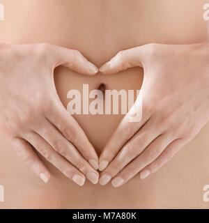 Donna messa a forma di cuore intorno all ombelico. Foto Stock