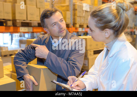 Due i responsabili del magazzino inventario di controllo in un grande magazzino Foto Stock