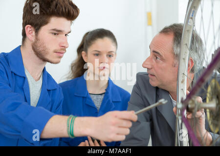 I giovani apprendisti riparare la ruota di bicicletta Foto Stock