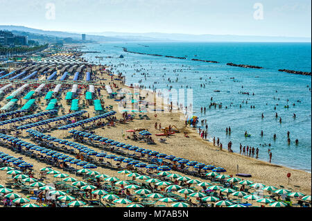 Sovraffollamento turistico spiaggia balneare con ombrelloni, Lungomare Cristoforo Colombo, Molise, Italia Foto Stock