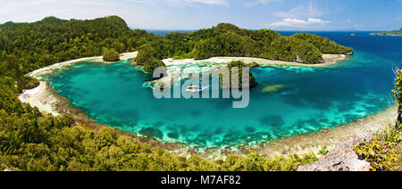 Una vista panoramica di una goletta di Bugis, live-a bordo della nave di immersione, al di ancoraggio in un isola di calcare laguna, Uranie Isola, Raja Ampat, Papua Occidentale, Indonesi Foto Stock