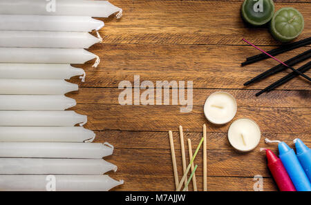 Bastone bianco candele e round clandes profumati, con molti bastoni di incenso sulla parte superiore di una luce sullo sfondo di legno Foto Stock