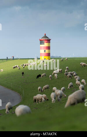 Germania, Bassa Sassonia, Frisia orientale, Krummhörn, pecore sulla diga vicino al faro di Pilsum, noto anche dal film con il comico Otto Waalkes, Foto Stock