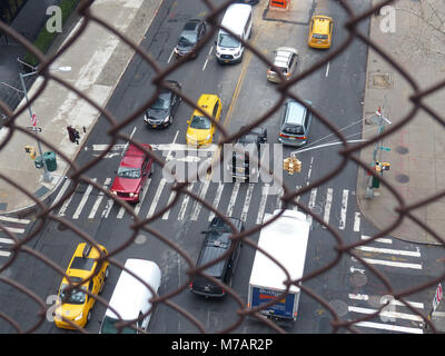 Il traffico automobilistico su York Avenue fotografato attraverso la catena agganciata recinzione di Queensboro Brdge Foto Stock