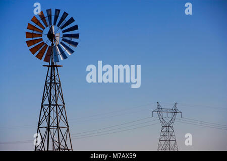 Il mulino a vento di industriale con un traliccio di elettricità in background, Arizona, Stati Uniti d'America Foto Stock