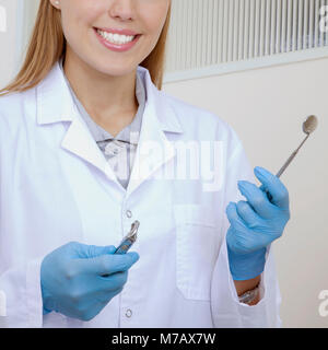 Dentista femmina holding apparecchiatura dentale Foto Stock