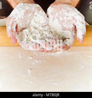 Chef's mani coperte con farina Foto Stock
