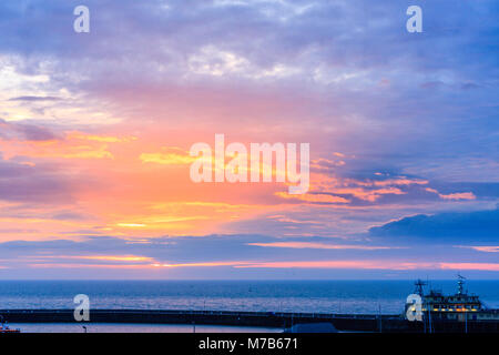 Inghilterra, Ramsgate porto. Alba sul canale Inglese. Nuvole e cielo blu con evidenza di colore brillante durante l'alba e tramonto, sun non effettivamente visto, dietro il cloud. Foto Stock