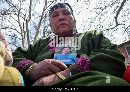 Srinagar, India. Decimo Mar, 2018. Un relativo può contenere una fotografia di una persona scomparsa durante una manifestazione di protesta organizzata dalla Associazione dei Genitori di Persone scomparse (APDP) a Srinagar, Indiano Kashmir amministrato. Membri della APDP riuniti per la loro dimostrazione mensile e ha chiesto la creazione di una commissione indipendente per indagare sulle sparizioni nella regione. Credito: Saqib Majeed SOPA/images/ZUMA filo/Alamy Live News Foto Stock