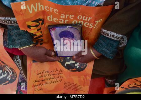 Srinagar, India. Decimo Mar, 2018. Un relativo può contenere una fotografia di una persona scomparsa durante una manifestazione di protesta organizzata dalla Associazione dei Genitori di Persone scomparse (APDP) a Srinagar, Indiano Kashmir amministrato. Membri della APDP riuniti per la loro dimostrazione mensile e ha chiesto la creazione di una commissione indipendente per indagare sulle sparizioni nella regione. Credito: Saqib Majeed SOPA/images/ZUMA filo/Alamy Live News Foto Stock