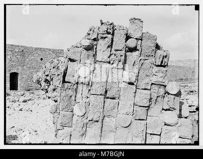Questa immagine presenta una vista ravvicinata di una sezione di muro caduto presso il castello di Cesarea, con colonne incorporate. La fotografia evidenzia le caratteristiche architettoniche dell'antica struttura. Foto Stock