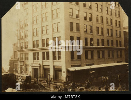 Un'immagine storica relativa a un'operazione di lavorazione della frutta a guscio, in cui le noci vengono importate, incrinate e prelevate in fabbriche o case. La fotografia evidenzia la forza lavoro coinvolta, con famiglie che lavorano in case autorizzate. Foto Stock