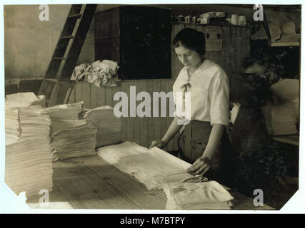 15-enne ragazza asciugamani di piegatura in Bonanno servizio lavanderia. LOC nclc.05198 Foto Stock