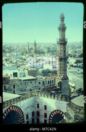 Questa fotografia mostra una vista del Cairo dalla moschea di Ibn Touloun, offrendo una prospettiva panoramica dello skyline e dell'architettura della città. L'immagine mette in evidenza le strutture storiche del Cairo e il suo paesaggio urbano. Foto Stock