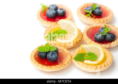 Set di gustose tortine con limone e confettura di lamponi isolato Foto Stock
