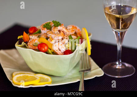 Close-up di insalata di gamberetti servita con vino bianco Foto Stock