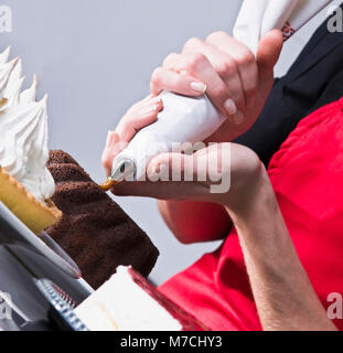 Metà vista in sezione di una femmina di chef ciliegina di una torta Foto Stock