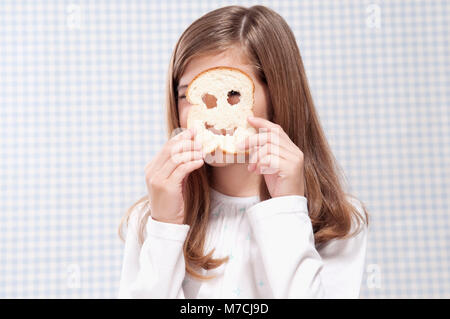 Close-up di una ragazza cerca attraverso una fetta di pane Foto Stock