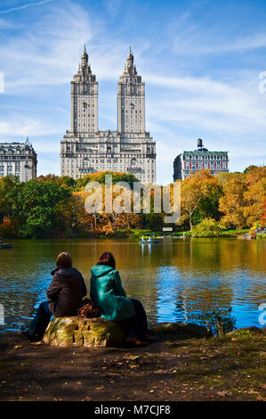 I turisti seduti in riva al fiume, Central Park, Manhattan, New York City, nello Stato di New York, Stati Uniti d'America Foto Stock