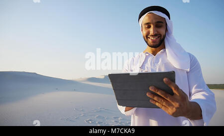 Successo imprenditore arabo detiene nelle mani e utilizza tablet, s Foto Stock