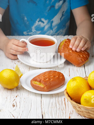 La colazione bambino tè freschi e dolci fatti in casa con ripieno di limone. Stile rustico. Messa a fuoco selettiva Foto Stock