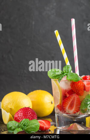 Estate un rinfrescante limonata. Bere con limone, fragole, menta, il basilico e il ghiaccio. Detox. Acqua minerale. Messa a fuoco selettiva Foto Stock