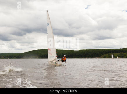 Regata a serbatoio di Kharkov 2017 Barca a vela si sposta sulle onde di una giornata di vento contro una nuvola sfondo cielo Foto Stock