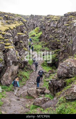 Thingvellir, Islanda - Luglio 19, 2017: i turisti a piedi attraverso il Almannagja linea anomalia nel mid-atlantic ridge Nord America placca a Thingvellir Na Foto Stock
