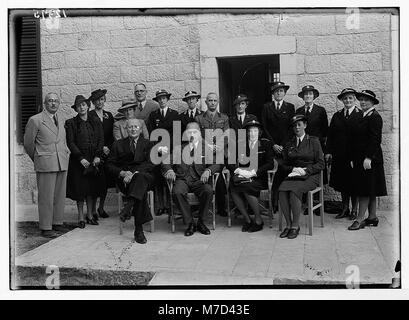Questa immagine mostra un piccolo gruppo di individui riuniti a Churchill House. La foto fornisce un'occhiata più da vicino ai partecipanti, catturandone espressioni e vestiti. Foto Stock