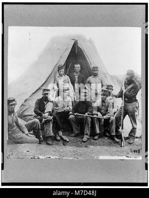 Un gruppo di soldati della compagnia G, 71st New York Volunteers, si trova di fronte a una tenda durante la guerra civile. L'immagine cattura i soldati in abbigliamento militare, mostrando il contesto storico dell'epoca. Foto Stock