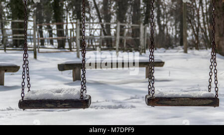 Bojcin foresta del parco, Serbia - coperto di neve set swing in un parco giochi per bambini al parco Foto Stock