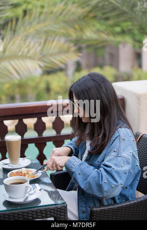 Turista femminile avente Prima colazione in Madinat Jumeirah Dubai EMIRATI ARABI UNITI Foto Stock