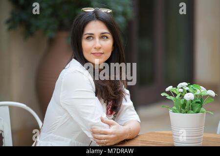 Bella donna che indossa gli occhiali da sole seduti in un caffè a Madinat Jumeirah Souk Dubai EMIRATI ARABI UNITI Foto Stock