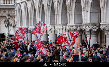 Bandiere sventolate e lanciati in aria in Piazza San Marco durante la Festa delle Maria cerimonia. La sfilata ha luogo durante il Carnevale di Venezia. Foto Stock