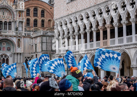 Bandiere sventolate e lanciati in aria in Piazza San Marco durante la Festa delle Maria cerimonia. La sfilata ha luogo durante il Carnevale di Venezia. Foto Stock