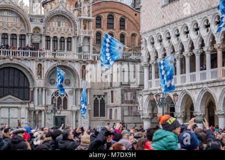 Bandiere sventolate e lanciati in aria in Piazza San Marco durante la Festa delle Maria cerimonia. La sfilata ha luogo durante il Carnevale di Venezia. Foto Stock