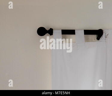 In prospettiva di una porzione di una tenda bianca su una rampa di nero contro un muro bianco immagine in formato paesaggio con spazio di copia Foto Stock